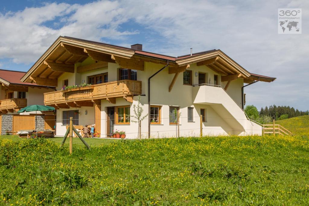 uma casa no topo de uma colina relvada em Appartement Lindner Hannes em Westendorf