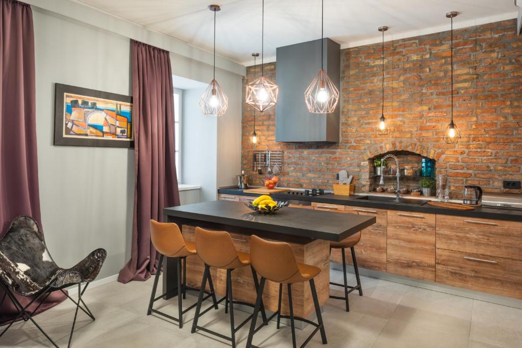 a kitchen with a table and chairs and a brick wall at St. Mark's Boutique Apartment Zagreb in Zagreb