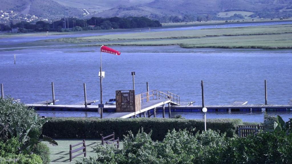 a dock on a river with a red flag on it at 18 on Tides End in Knysna