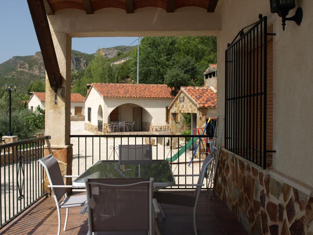 a balcony with a table and chairs and a house at El Tejo Yeste y Mirador del Segura in Yeste