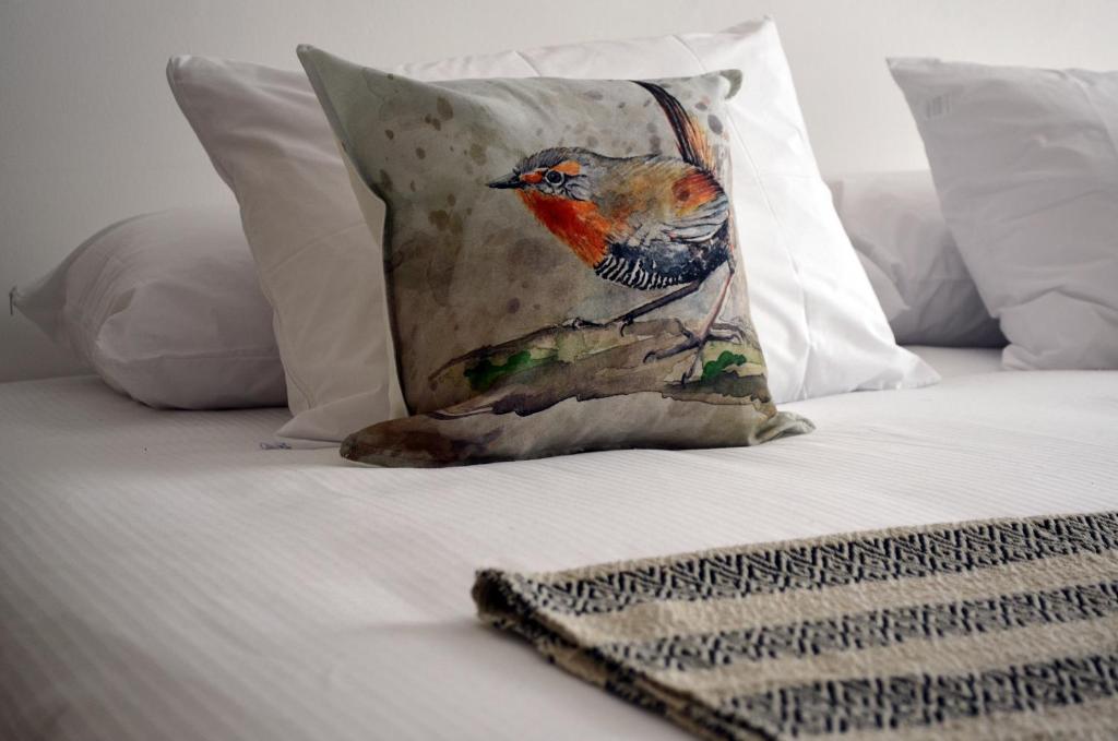 a bird sitting on a bed with a pillow on it at Hotel Nueve Ríos in Valdivia