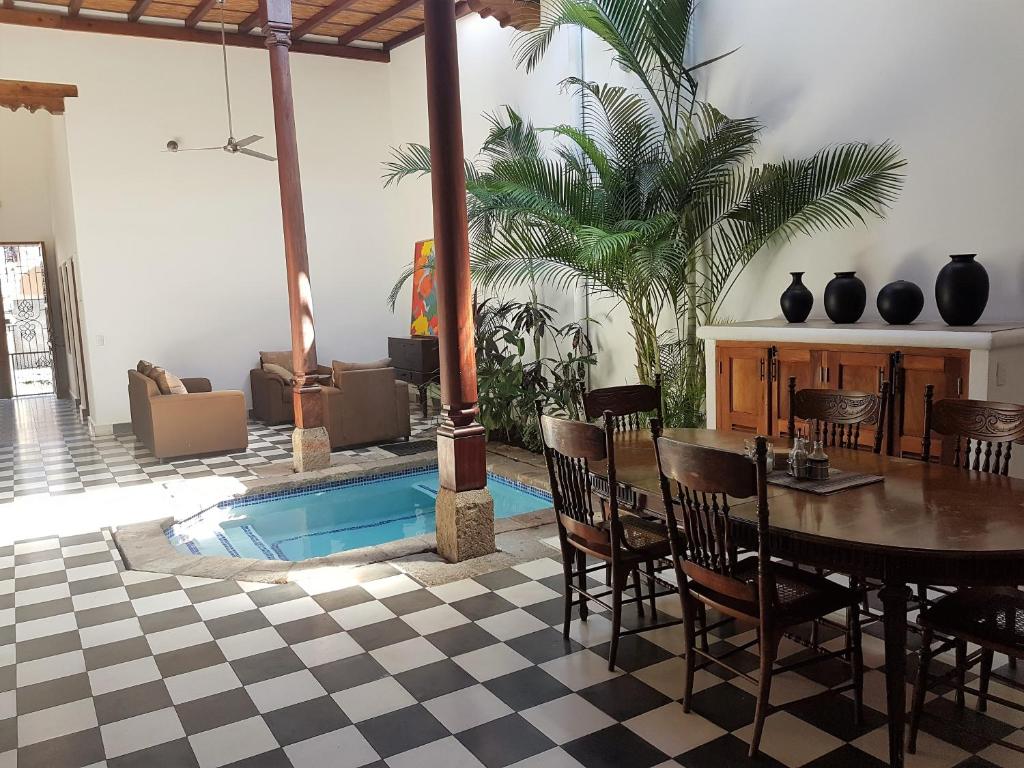 a living room with a table and a swimming pool at Lovely new-build colonial house with plunge pool in Granada