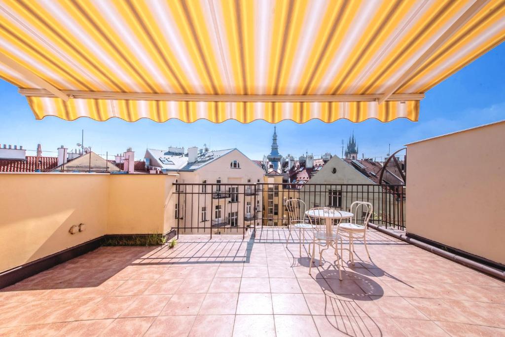 a balcony with a table and chairs and a view at Apartments Vezenska in Prague