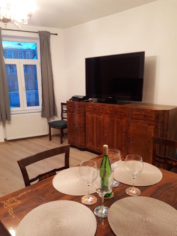 een eetkamer met een tafel met glazen en een televisie bij Casa Old Crown Brasov in Braşov