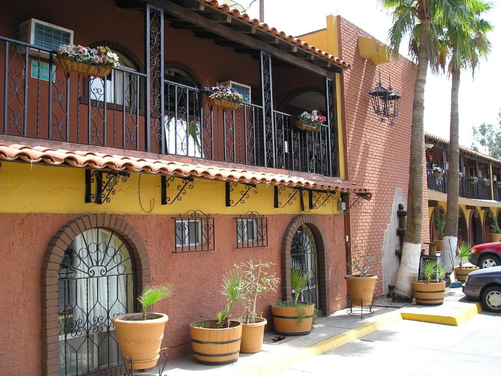 a building with potted plants on the side of it at Hacienda del Indio in Mexicali