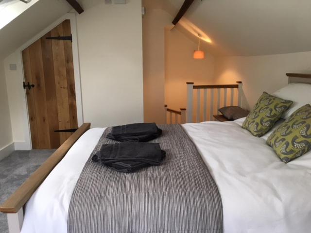 a large white bed with a black bag on it at The Cricketers Arms in Petworth