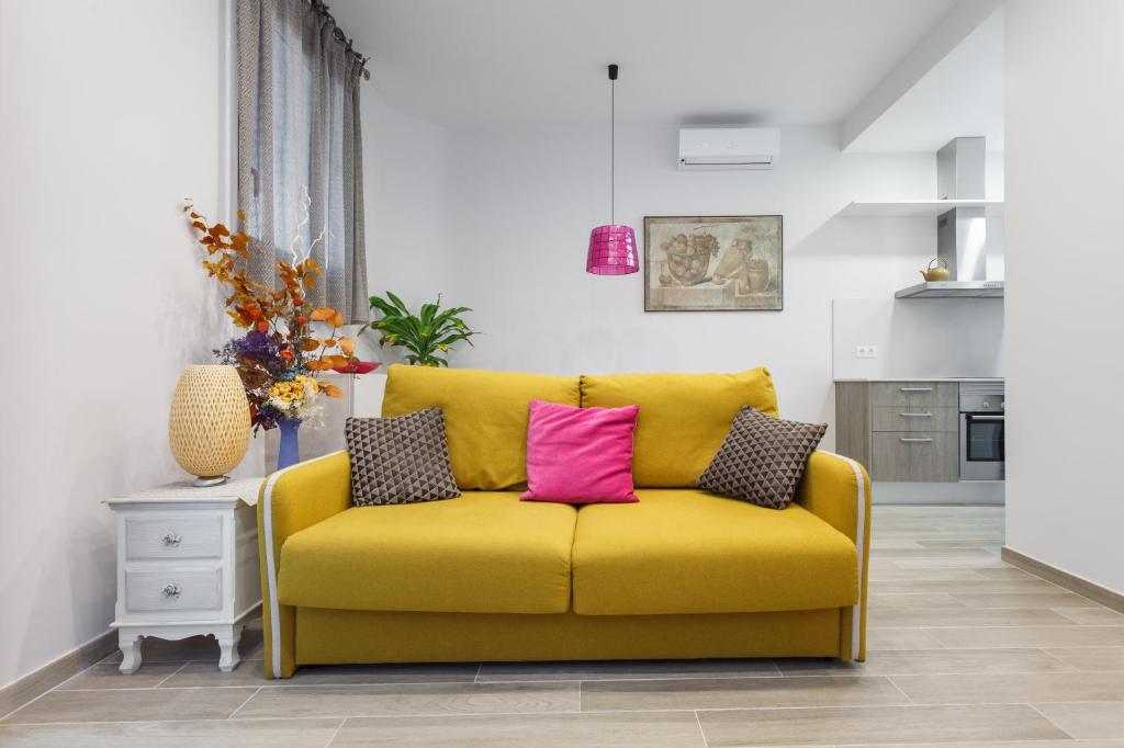 ロスピタレート・デ・リョブレガートにあるBeautiful Apartment 20 minutes from city centerのリビングルーム(黄色のソファ、枕3つ付)