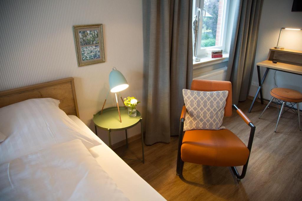 LöningenにあるFerienwohnung im Hasetalのベッドルーム1室(ベッド1台、椅子、ランプ付)