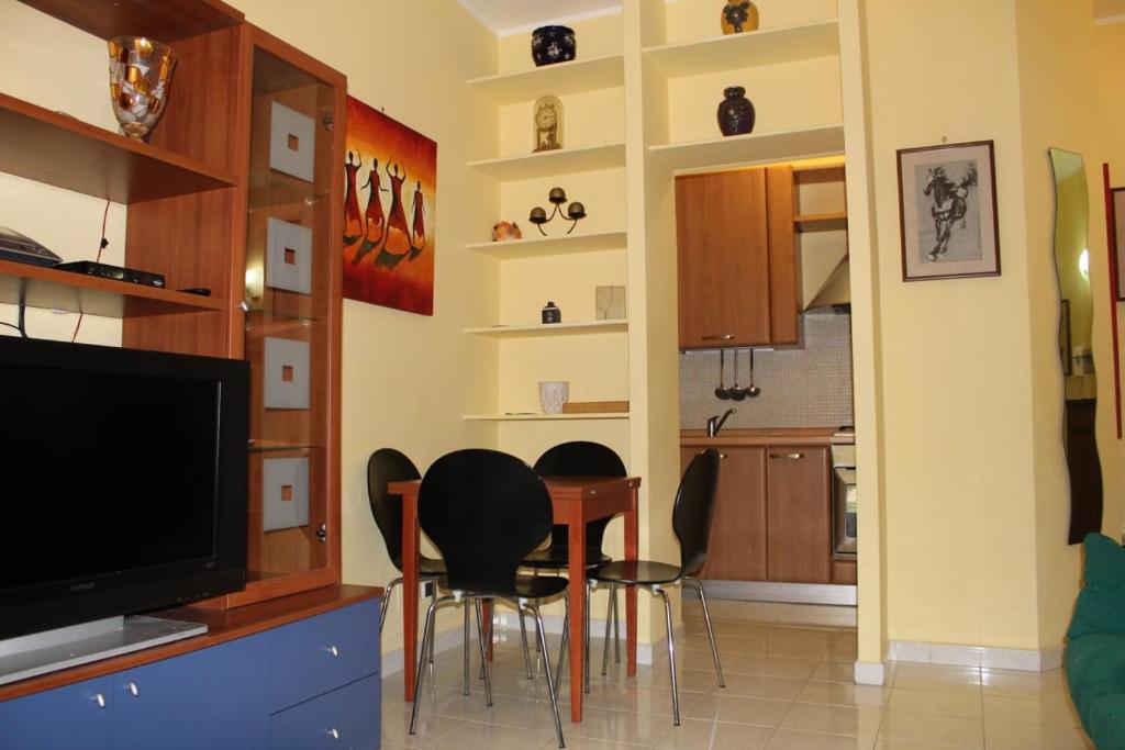 un soggiorno con tavolo, sedie e TV di Casa PieRosa a Frosinone