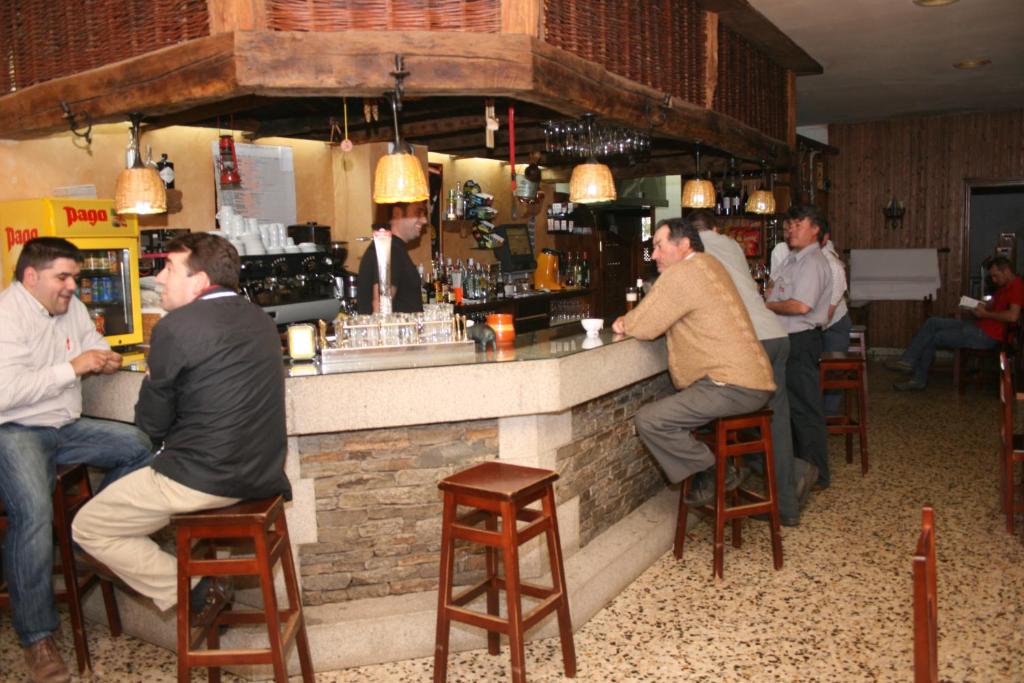 un grupo de hombres sentados en un bar en A taberna de vento en Lalín