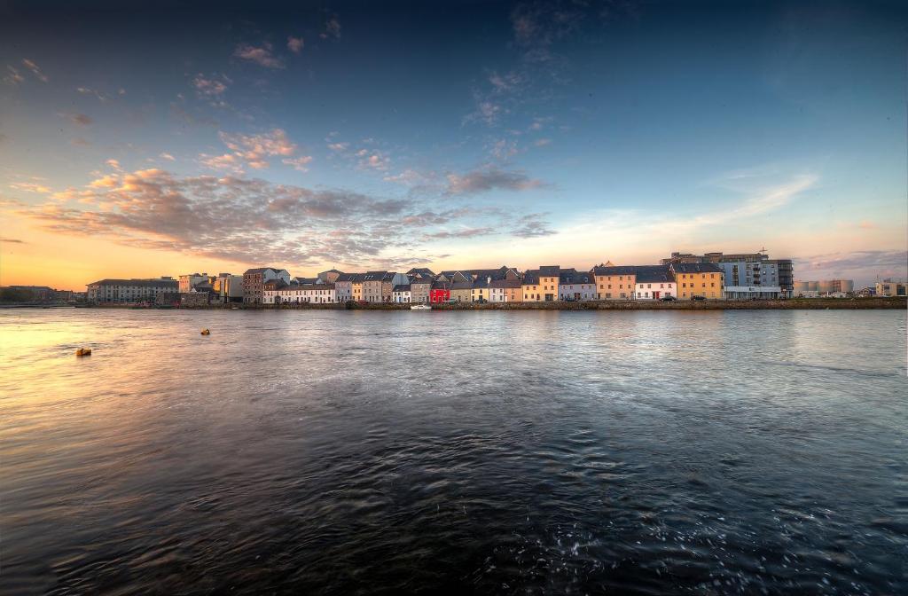a large body of water with buildings in the background at Spanish Arch in Galway