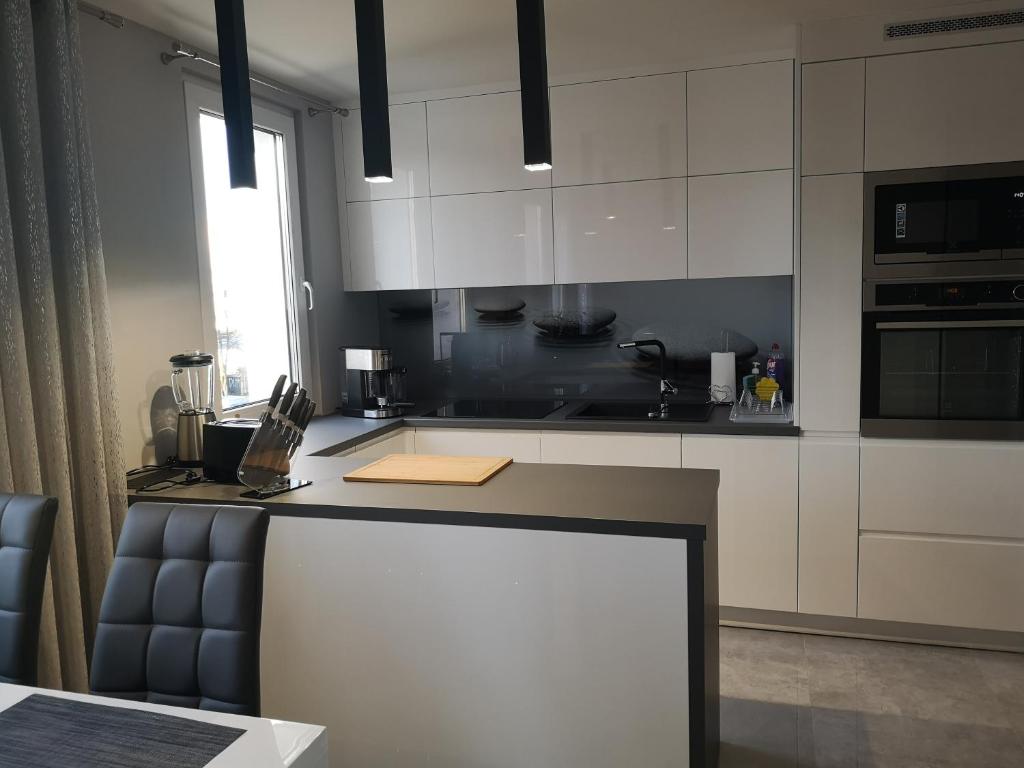 a kitchen with white cabinets and a counter top at Park Apartment 216 in Strzelce Opolskie