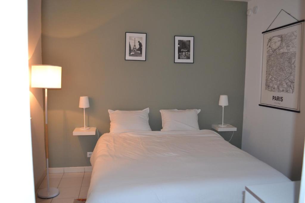 ein Schlafzimmer mit einem großen weißen Bett mit zwei Lampen in der Unterkunft Meudon : idéal pour séjour à Paris in Meudon