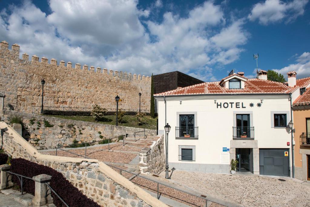 um edifício de hotel em frente a uma parede em Hotel Puerta de la Santa em Ávila