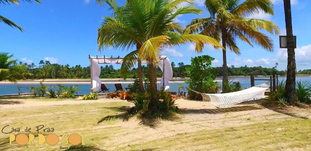 a hammock on the beach next to the water at Pôr do Sol Eco Suítes in Barra Grande