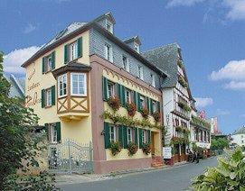 a large building with green shutters on a street at Mosel-Landhaus Hotel Oster in Ediger-Eller