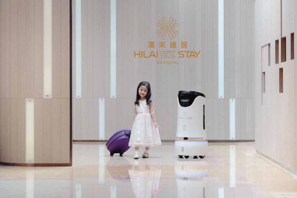 Una ragazza è in piedi accanto a un robot umanoide di Hi Lai EZ Stay a Kaohsiung