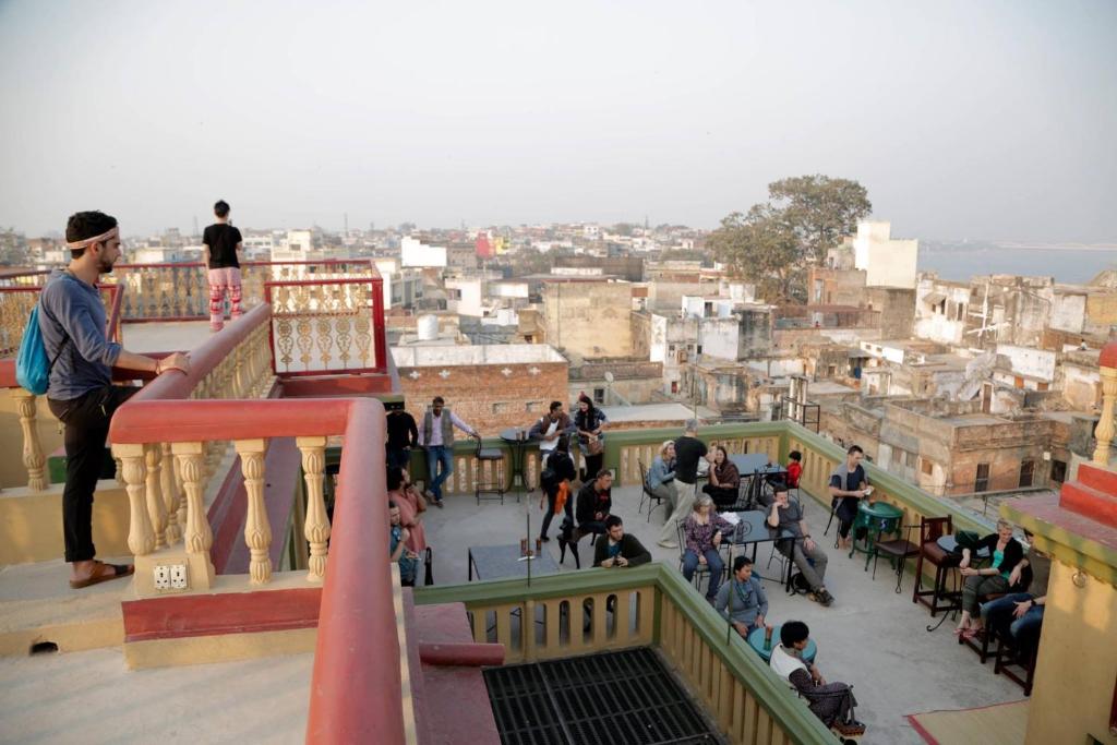 um grupo de pessoas de pé em uma varanda com vista para uma cidade em Ram Bhawan Residency em Varanasi