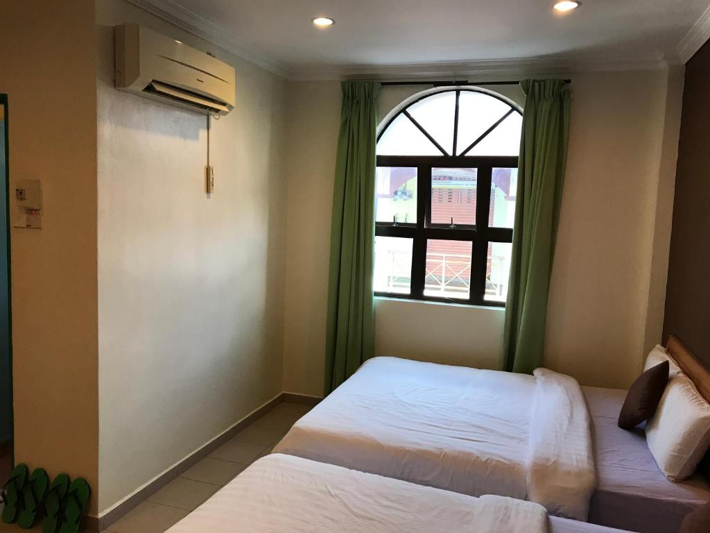 Postel nebo postele na pokoji v ubytování Kangsar Hotel