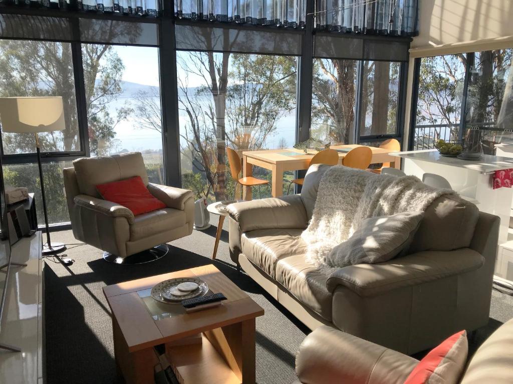 a living room with a couch and a chair at Tamar River Apartments in Rosevears