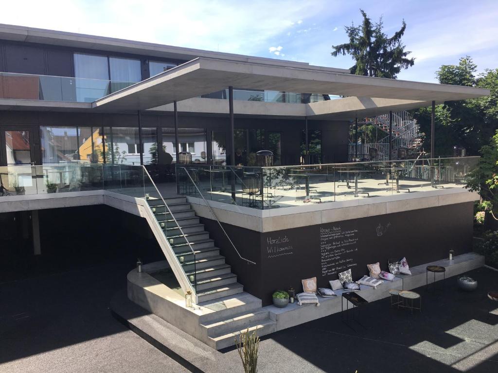 a building with a staircase and some chairs at Hotel Krone Design B&B in Weil am Rhein