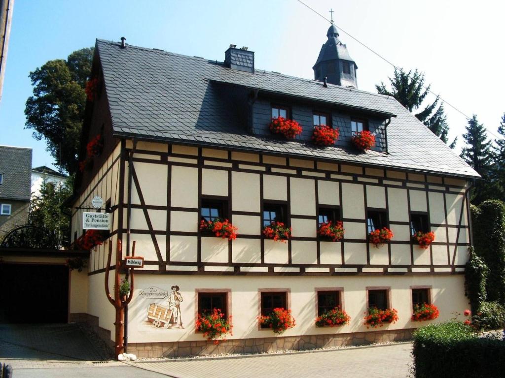 un edificio con flores en las ventanas en Dreibettzimmer-in-Wiesa, en Thermalbad Wiesenbad