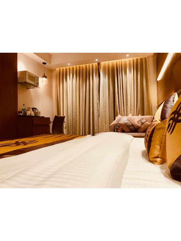 Postel nebo postele na pokoji v ubytování JRD Pride-Business Hotel