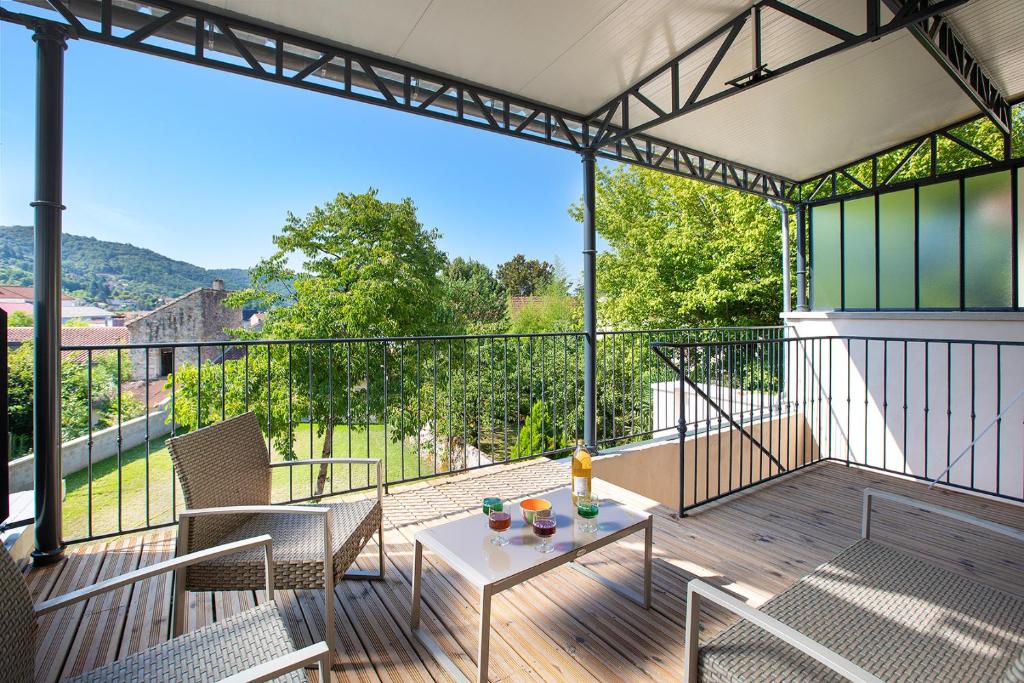 a patio with a table and chairs on a balcony at Le Gîte de Siloe in Villefranche-de-Rouergue