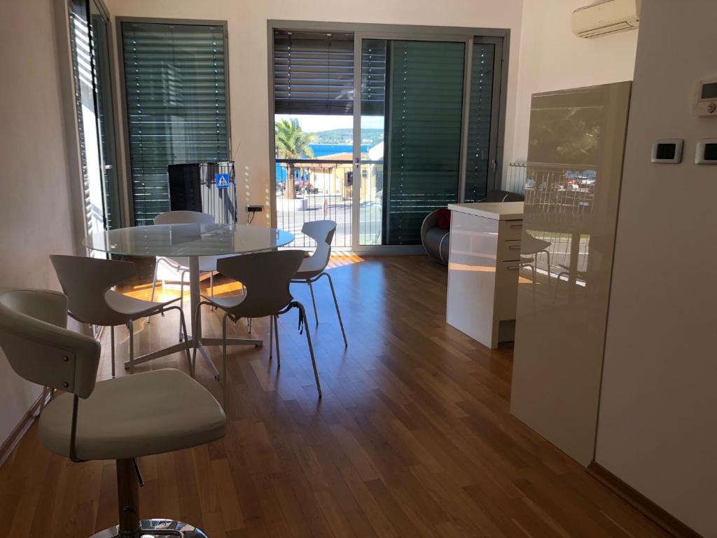 a living room with a table and chairs and a kitchen at Koper Sea Apartment in Koper