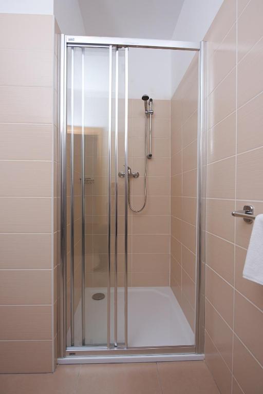 W łazience znajduje się prysznic ze szklanymi drzwiami. w obiekcie Hotel Slavia w mieście Svitavy