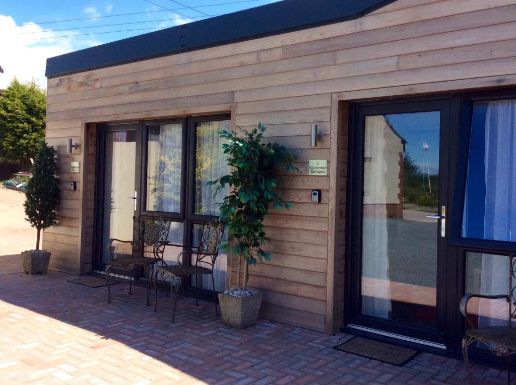 a building with windows and a potted plant on it at Cloverlea Cottages in Bristol