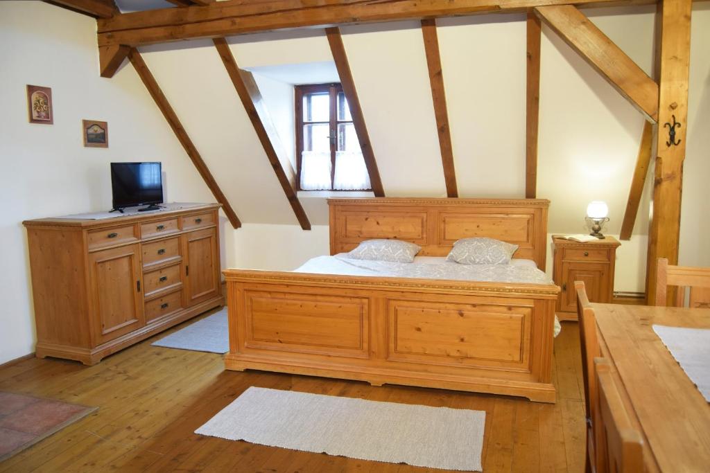 - une chambre avec un grand lit en bois et un bureau dans l'établissement Bučický mlýn, à Rožďalovice