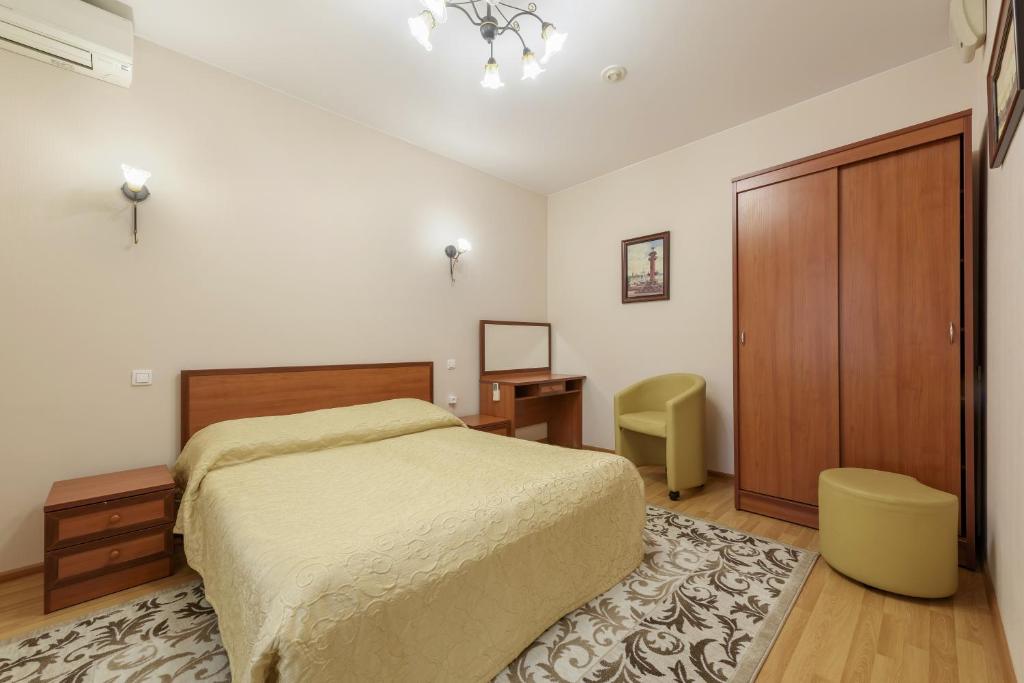 1 dormitorio con cama, escritorio y puerta en Nord House, en San Petersburgo