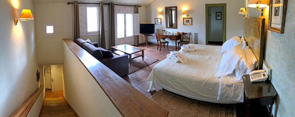 Hotel Leonor de Aquitania في كوينكا: غرفة نوم مع سرير وغرفة معيشة