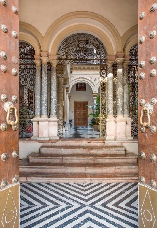 Hotel CoolRooms Palacio Villapanés 5 GL, an entrance to a building with stairs and pillars at CoolRooms Palacio Villapanés 5 GL in Seville