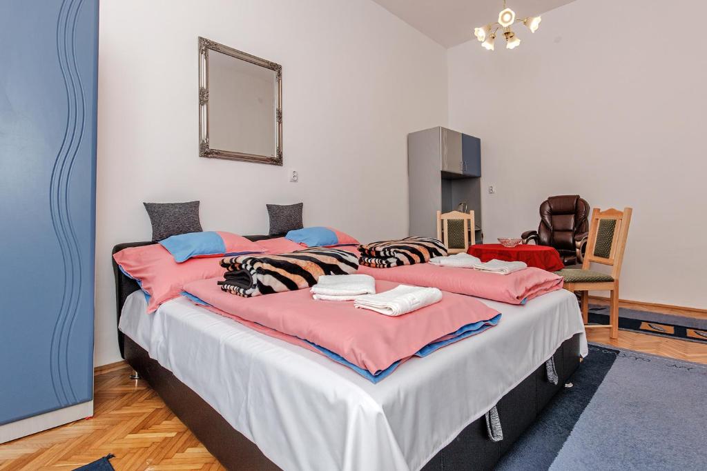エゲルにあるArany Csillag Apartmanのベッドルーム1室(ピンクとブルーの枕が付いた大型ベッド1台付)