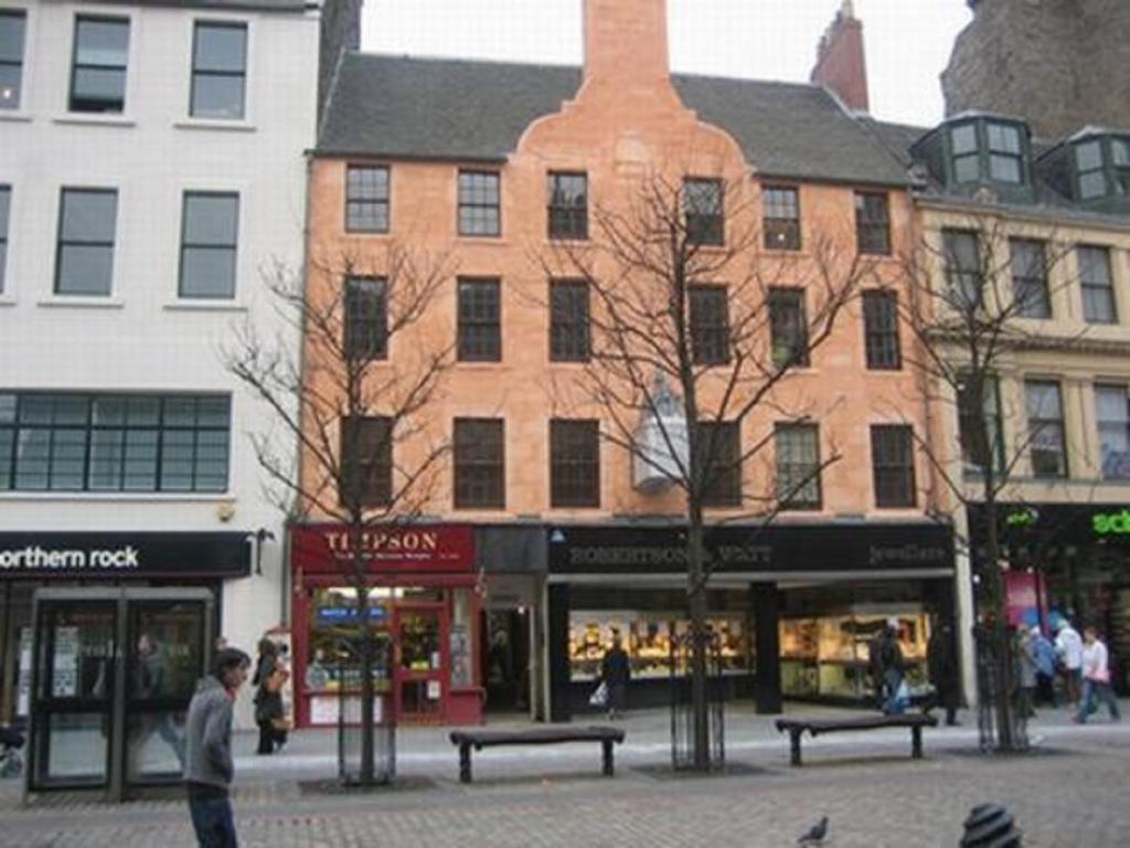 un grupo de edificios en una calle de la ciudad con bancos en Dundee Backpackers Hostel, en Dundee