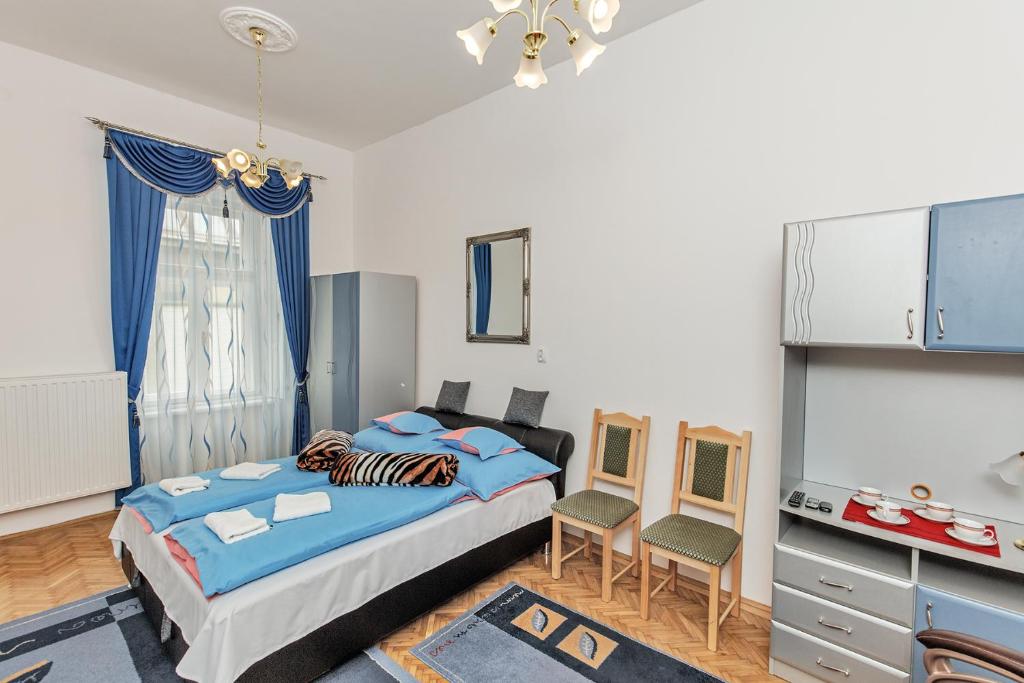 sypialnia z łóżkiem, stołem i krzesłami w obiekcie Arany Csillag Apartman w Egerze