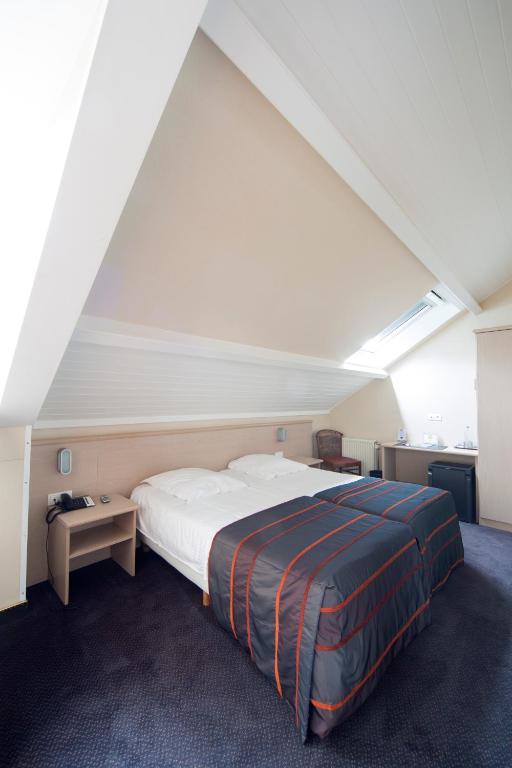 Postel nebo postele na pokoji v ubytování Hotel Leo Station, Villa et Annexes