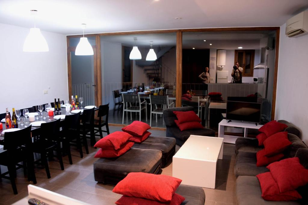 una sala de estar con sofás y almohadas rojas. en Casa Rural Las Voladas, en Alcalá del Júcar