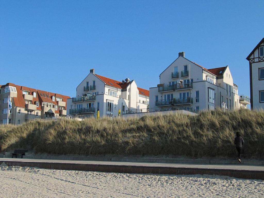 une personne se promenant sur la plage en face des maisons dans l'établissement Kaiserhof Apartment 14, à Wangerooge