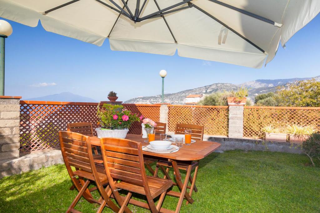 een patio met een tafel en stoelen en een parasol bij Shanti Home - Restaurant di Aversano Salvatore in Sorrento