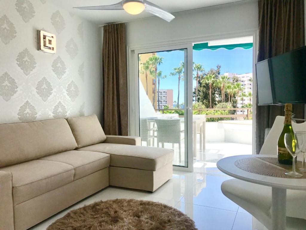 プラヤ・デ・ラス・アメリカスにあるStyle Apartment with Ocean viewのリビングルーム(ソファ、テーブル付)