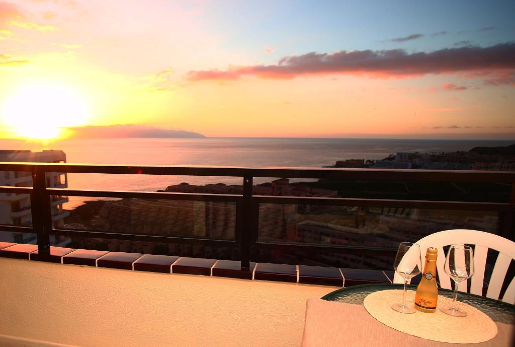 a table with a bottle of champagne on a balcony with the sunset at Sunset Paradise in Adeje