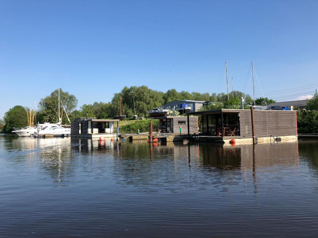 einen Yachthafen mit einem Haus auf dem Wasser in der Unterkunft Hausboot Resort Nordseeküste in Wilhelmshaven