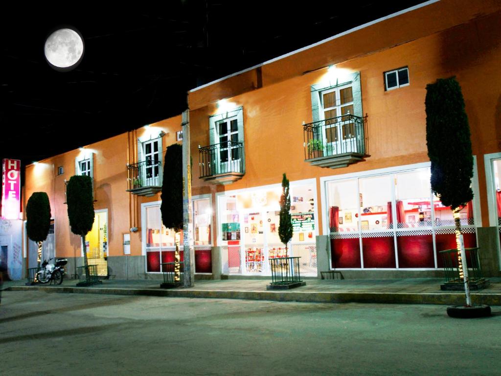 a building with a store front with a clock on it at Hotel Azucena in Huamantla