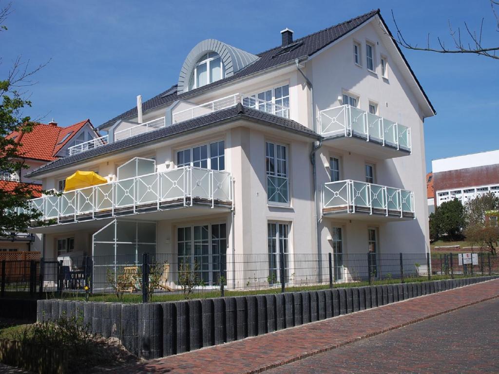 ein weißes Haus mit Balkon an der Seite in der Unterkunft Villa Vivaldi Whg 5 in Wangerooge