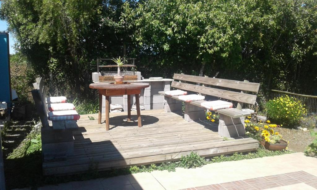a wooden deck with a table and a table and benches at La Maravilla Lodge in Vilches
