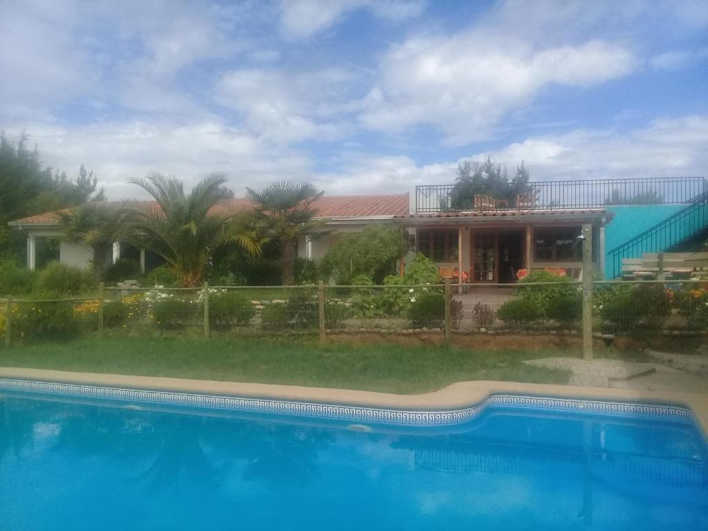 uma casa com piscina em frente a uma casa em La Maravilla Lodge em Vilches