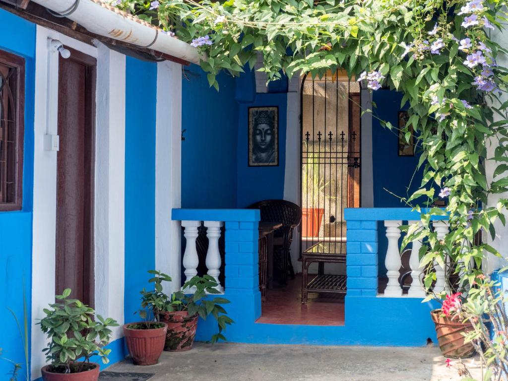 a blue house with a gate and plants at Villa Khatun Guesthouse in Panaji
